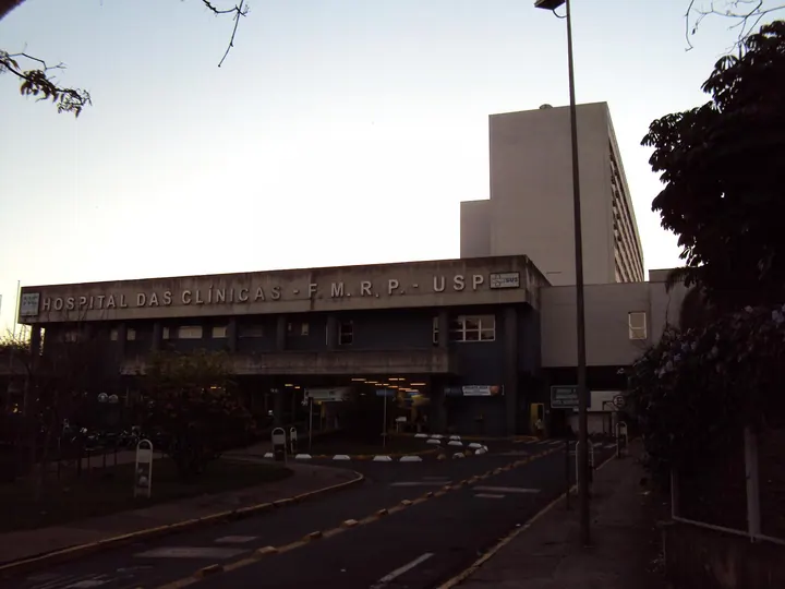 Entrada do Hospital das Clínicas da FMRP-USP, unidade Campus, com identificação na fachada e edifício ao fundo